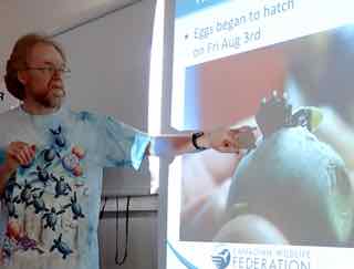 Photo of David Seburn with picture of turtle egg in the act of hatching