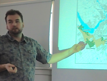 Photo of Alex Stone pointing to map showing Macoun Club Study Area in Greenbelt's Stony Swamp