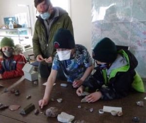 Photo of Macoun Club group laying out rock and mineral specimens on a table