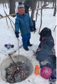 Photo of toasting marshmallows over a wintertime fire on a Macoun Club field trip.