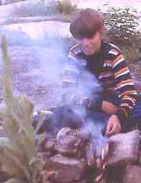 Photo of Macoun Club member Lorin Gaertner tending a campfire at Pakenham's Upper Pond