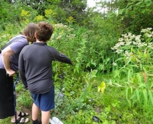 Photo of a Macoun Club member pointing to a frog in the pond
