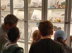 Photo of Macoun Club group looking at Mike Leveille's nature collection