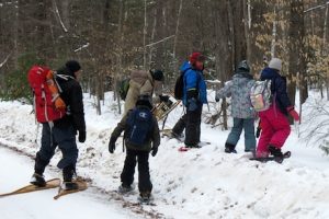 Photo of Macoun Club group entering forest on snowshoes