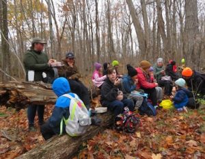 Photo of Macoun Club group gathered together for lunch in the woods